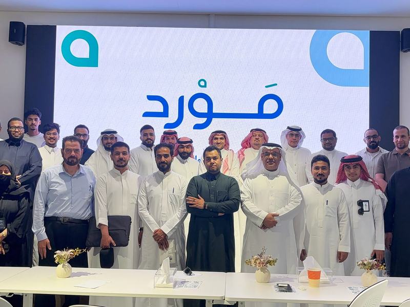 صورة جماعية للمشاركين في ختام الورشة أمام شعار مَوْرِد بمجمع وادي جدة للابتكار
